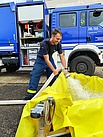 THW-Helfer befüllt ein Wasserbecken mit einem Schlauch